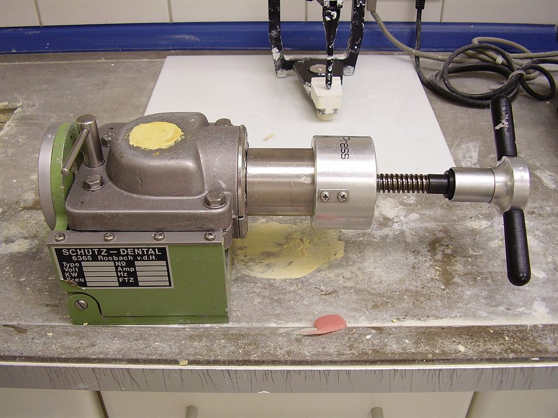 A denturist adjusting a denture in the lab